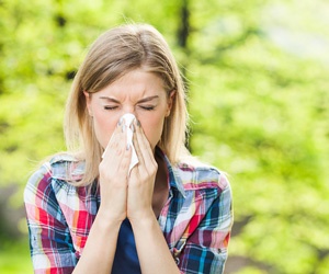 Woman sneezing suffering from allergies