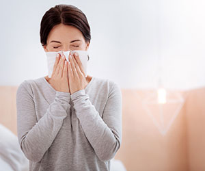 Woman sneezing suffering from allergies